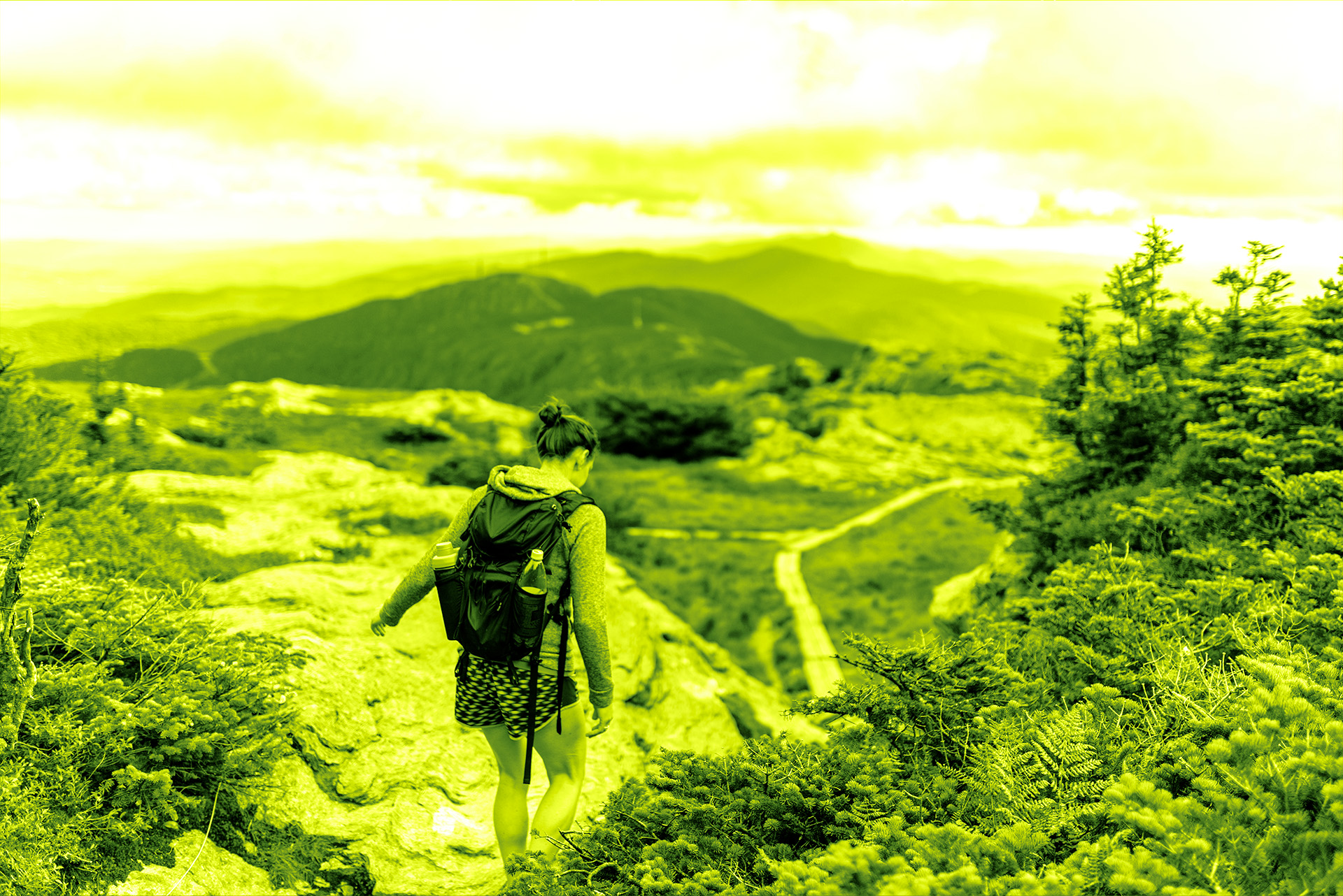 Featured image for a PR attribution blog. Female hiker with a backpack walking along a mountain trail.